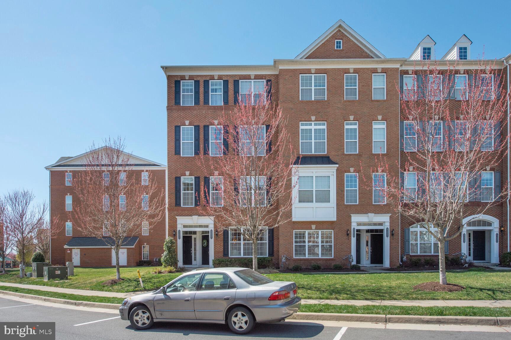 43037 Clarks Mill Terrace Ashburn, VA 20148 - Photo 1 of 28 a front view of a residential apartment building with a yard
