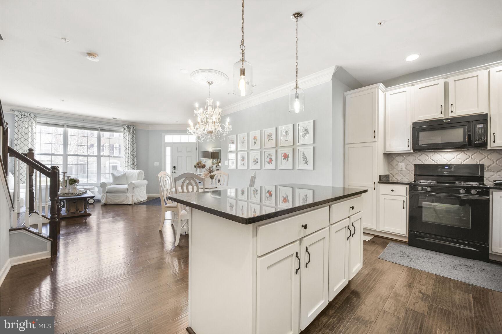 43037 Clarks Mill Terrace Ashburn, VA 20148 - Photo 13 of 28 a kitchen with granite countertop a stove and a wooden floors