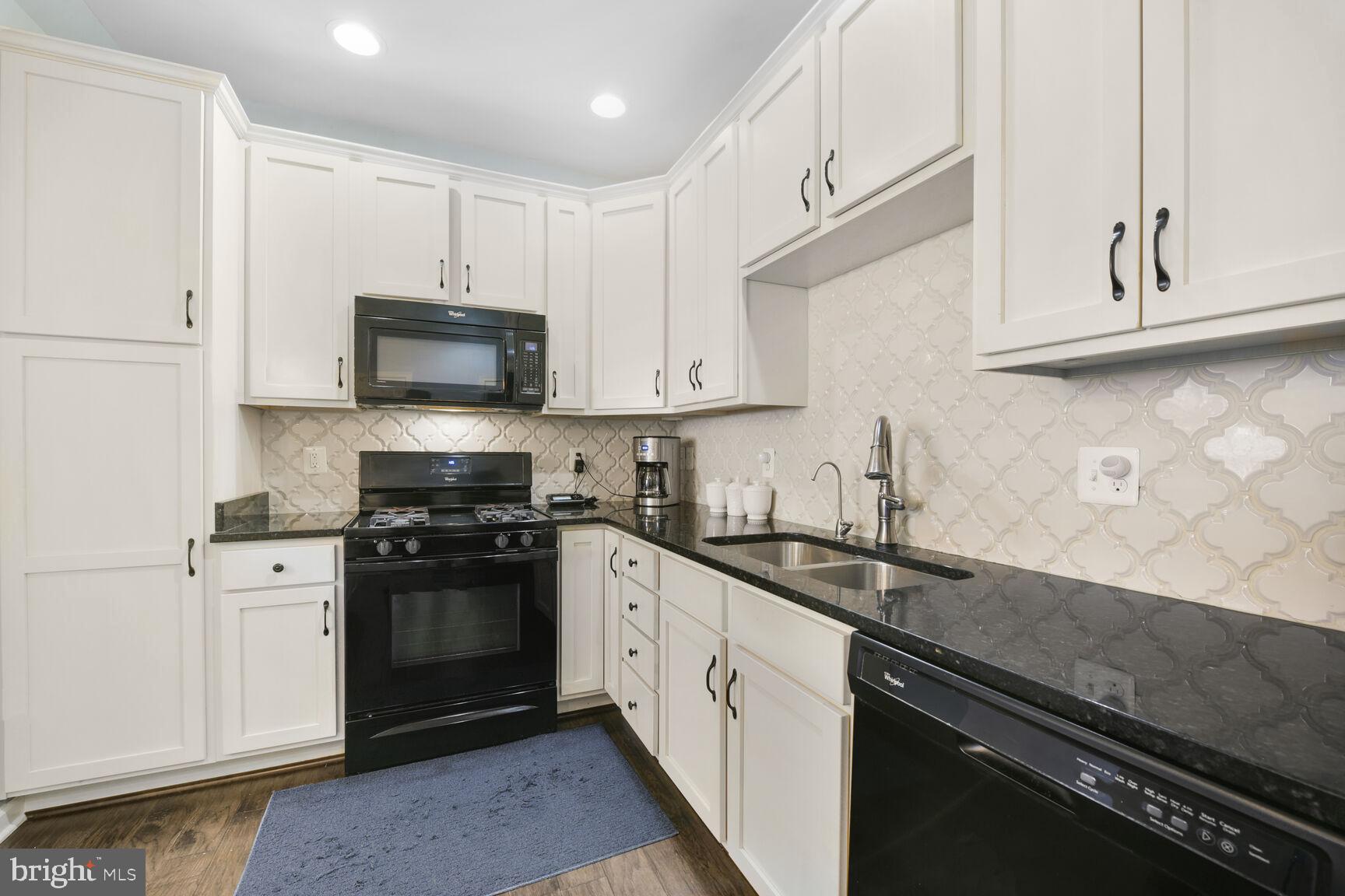 43037 Clarks Mill Terrace Ashburn, VA 20148 - Photo 15 of 28 a kitchen with stainless steel appliances granite countertop a sink a stove a microwave and cabinets