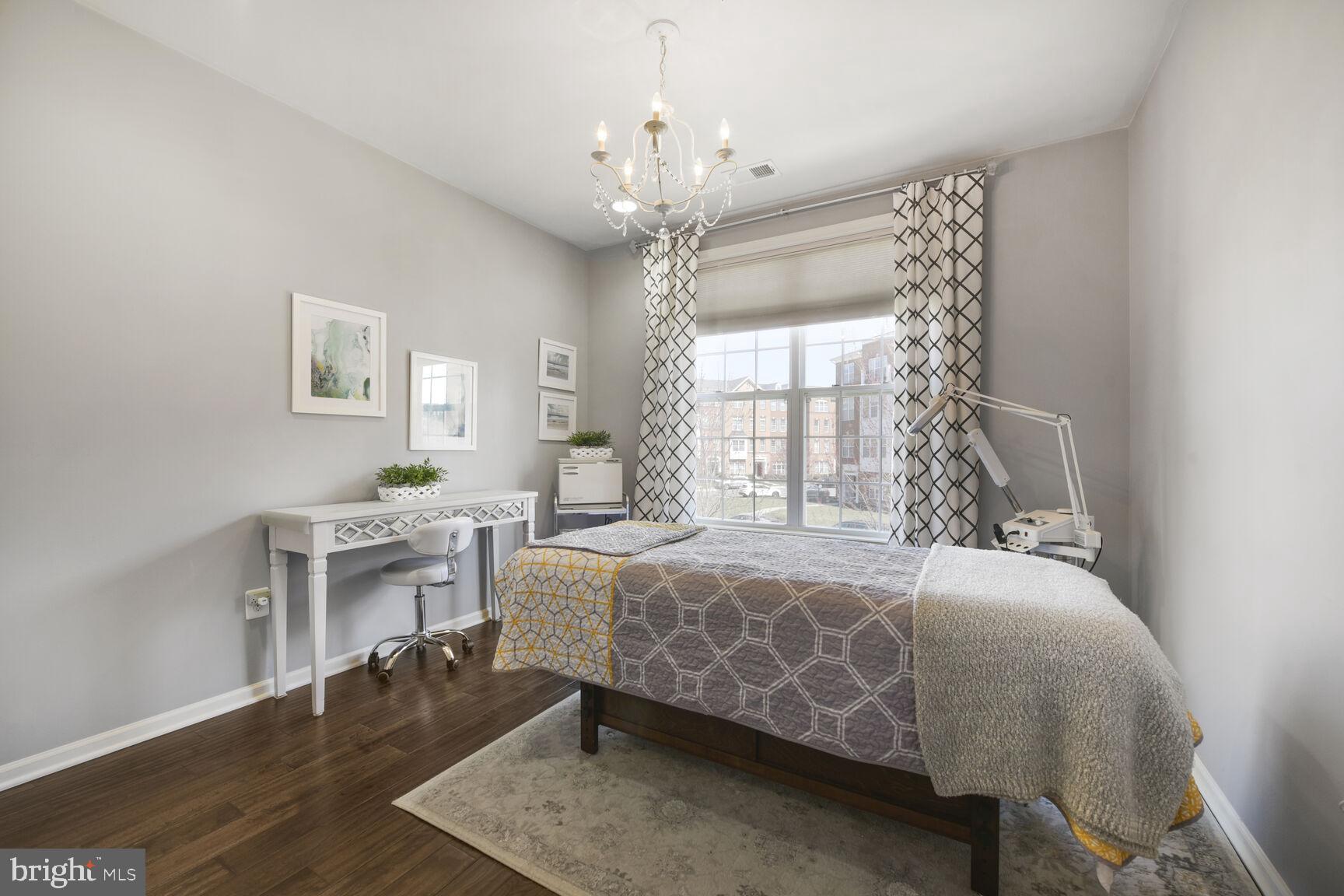 43037 Clarks Mill Terrace Ashburn, VA 20148 - Photo 16 of 28 a bedroom with a bed and a chandelier