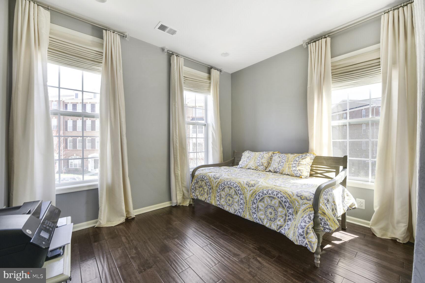 43037 Clarks Mill Terrace Ashburn, VA 20148 - Photo 17 of 28 a bedroom with a bed and wooden floor