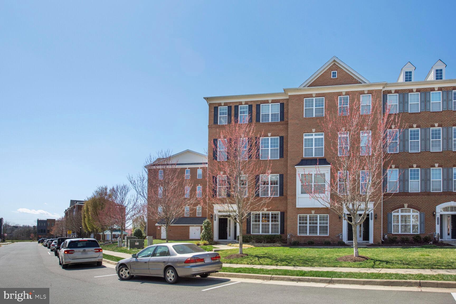 43037 Clarks Mill Terrace Ashburn, VA 20148 - Photo 2 of 28 a front view of a residential apartment building with a yard