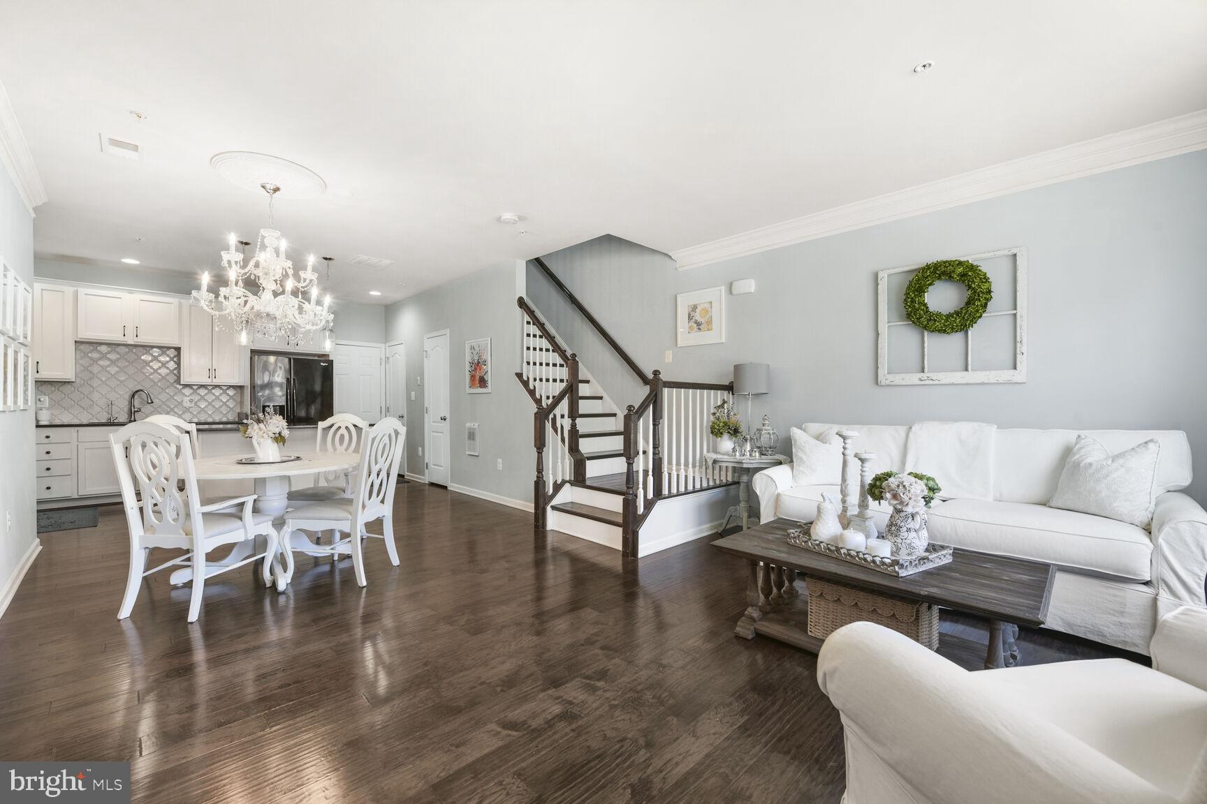 43037 Clarks Mill Terrace Ashburn, VA 20148 - Photo 4 of 28 a living room with couches chairs and kitchen view with wooden floor