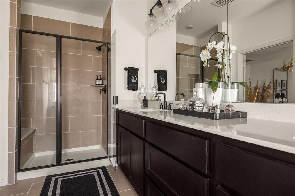7537 Laburnam Road Dallas, TX 75228 - Photo 23 of 30 Dual vanity with stone countertop, dark wood-finish cabinetry, and matte black fixtures