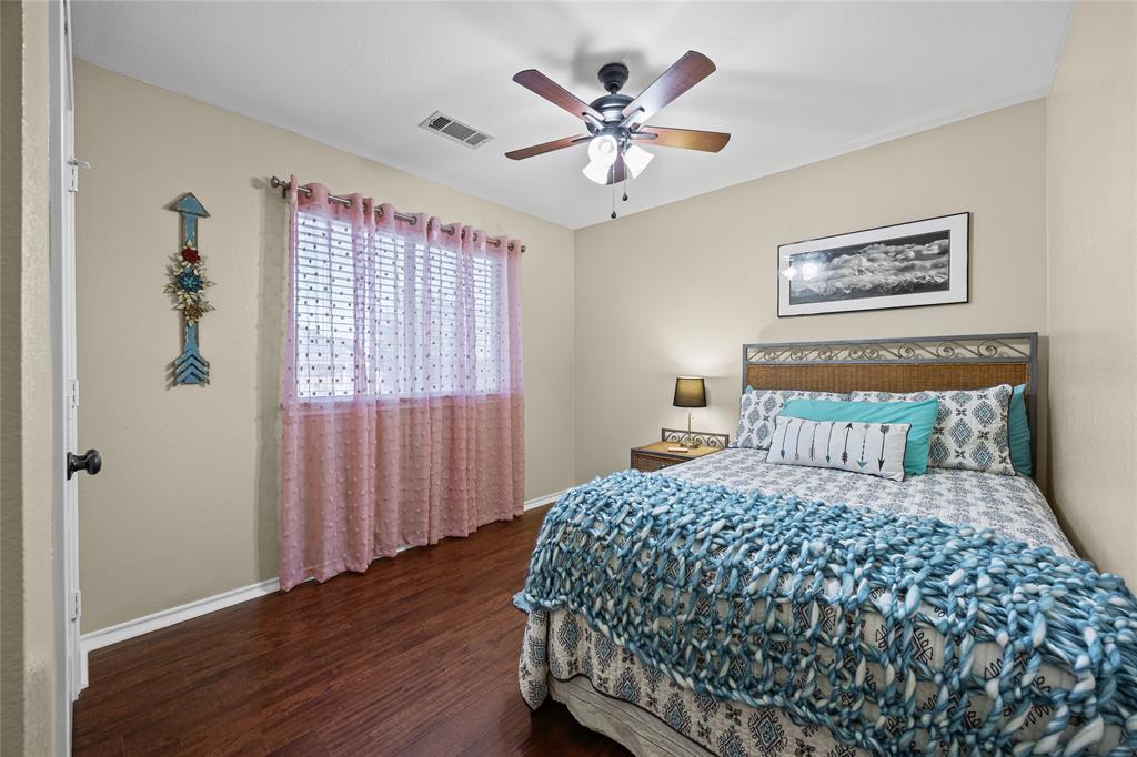 112 Springfield Lane Red Oak, TX 75165 - Photo 23 of 40 a bedroom with a large bed and a chandelier