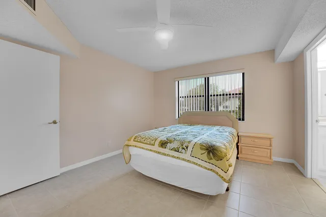 a bedroom with a bed and a ceiling fan