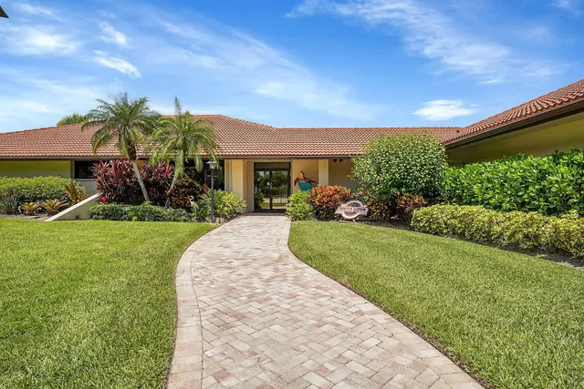 an aerial view of a house with a garden and lake view