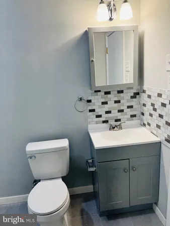 a bathroom with a sink toilet and mirror