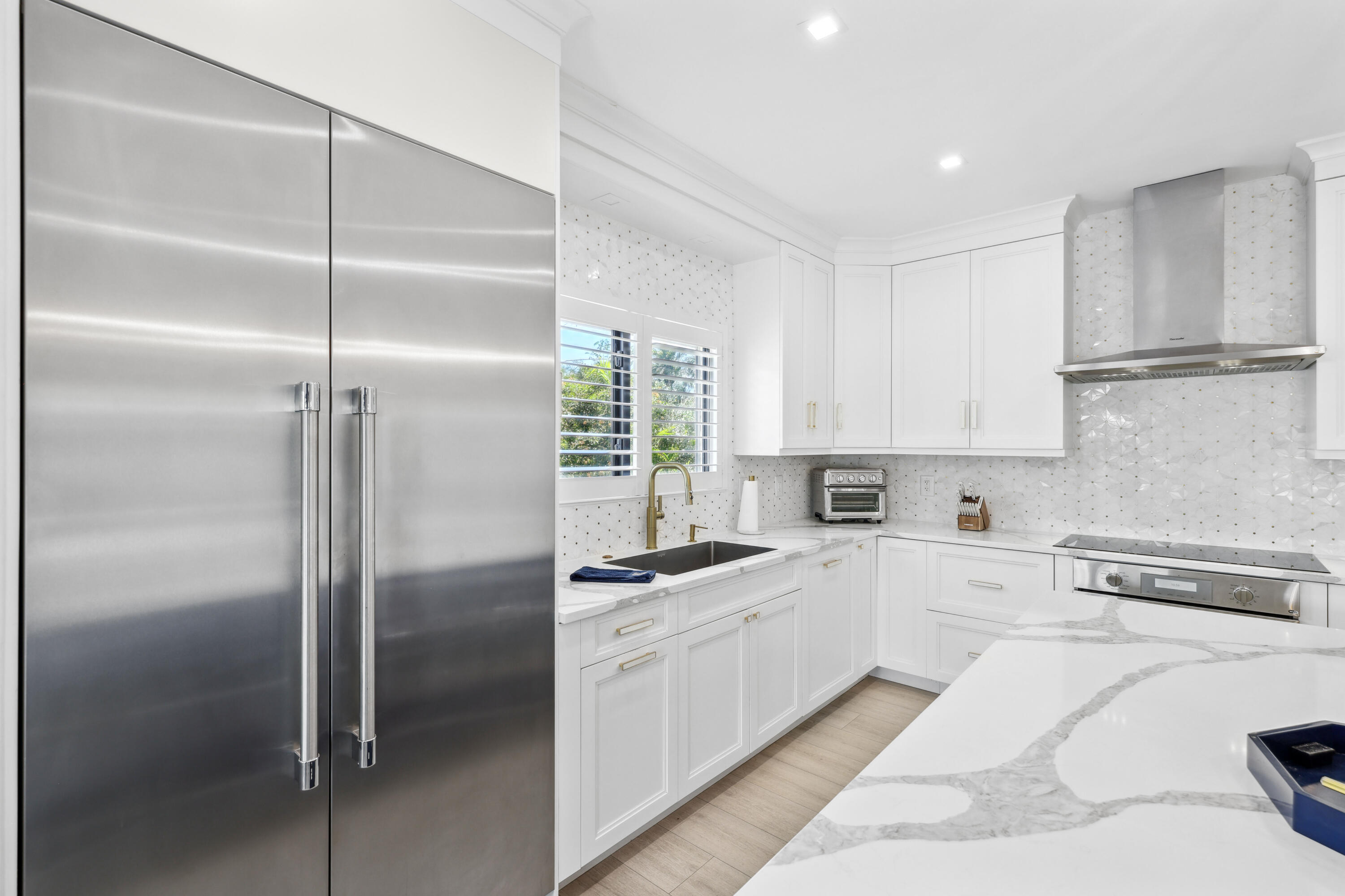 125 Marlin Drive Ocean Ridge, FL 33435 - Photo 19 of 122 a kitchen with a refrigerator a sink and cabinets