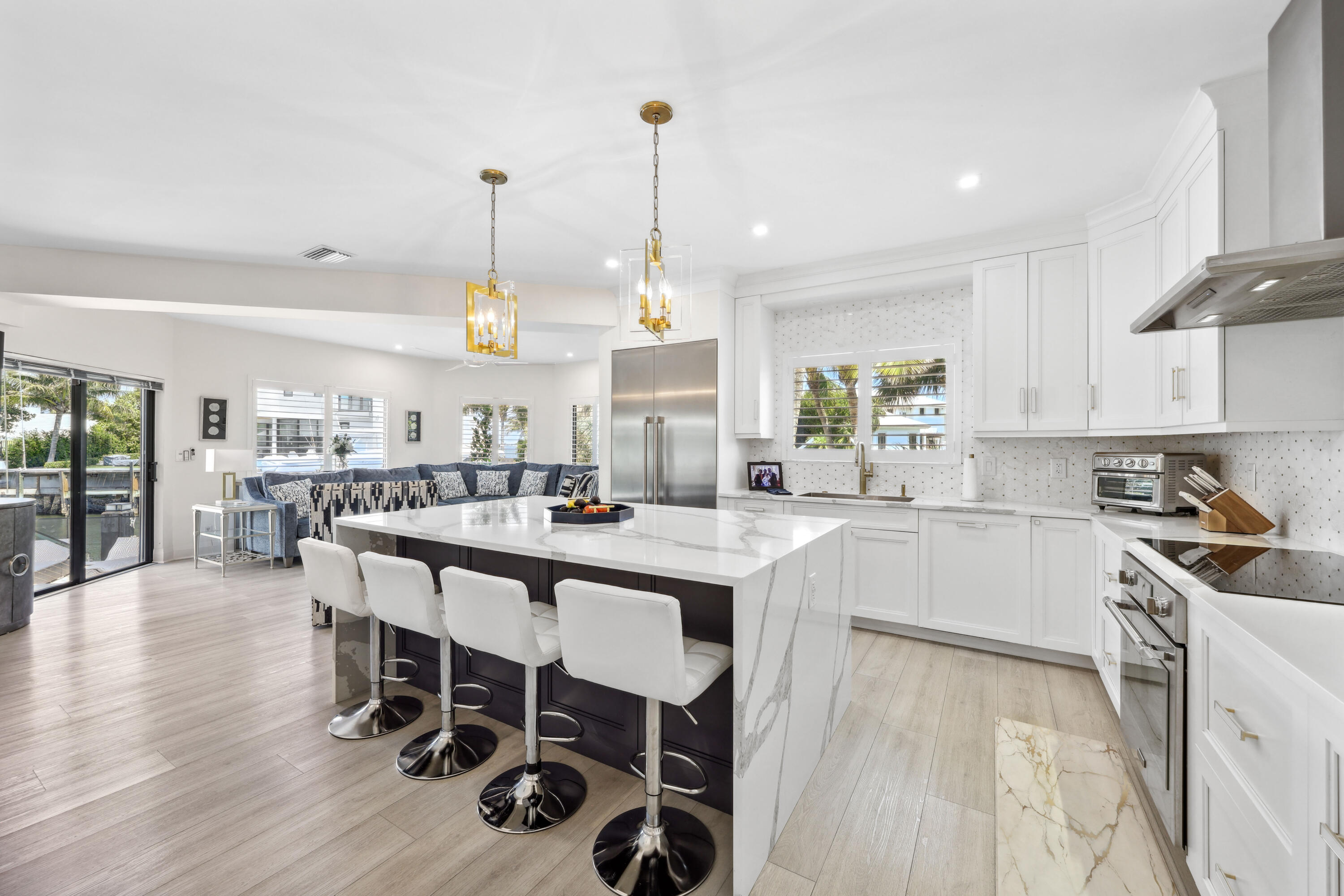 125 Marlin Drive Ocean Ridge, FL 33435 - Photo 23 of 122 a kitchen with stainless steel appliances a dining table chairs stove and white cabinets