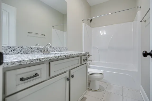 a bathroom with a granite countertop toilet a sink and a mirror