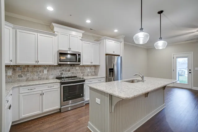 a kitchen with a sink a microwave a stove and cabinets