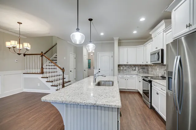 a kitchen with counter top space a sink appliances and cabinets