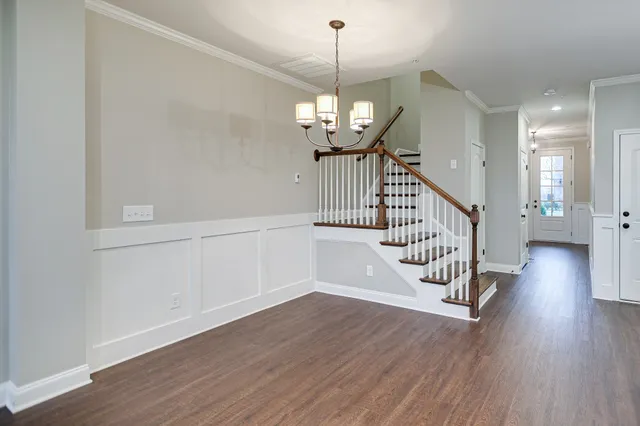 a view of a hallway with wooden floor and staircase