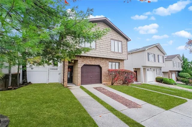 a front view of a house with a garden and yard
