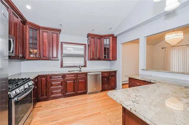 a kitchen with stainless steel appliances granite countertop wooden cabinets a stove top oven a sink and dishwasher