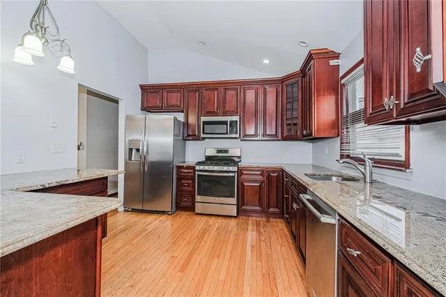 a kitchen with stainless steel appliances granite countertop a refrigerator microwave and sink