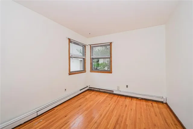 an empty room with a window and wooden floor
