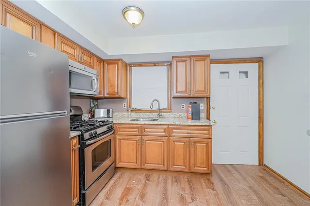 a kitchen with stainless steel appliances granite countertop a stove a sink dishwasher and a refrigerator