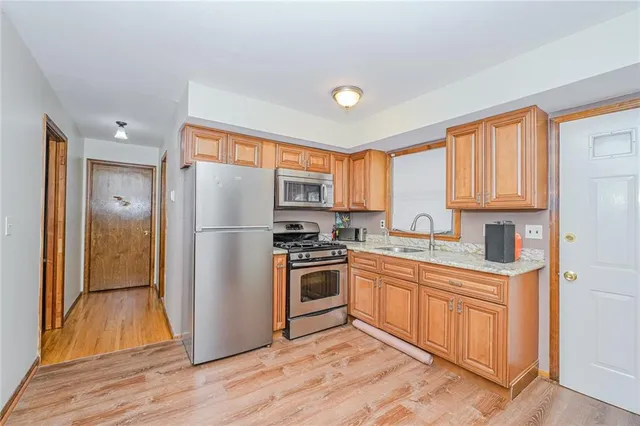 a kitchen with a refrigerator sink and cabinets