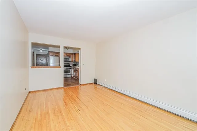 an empty room with wooden floor and a window