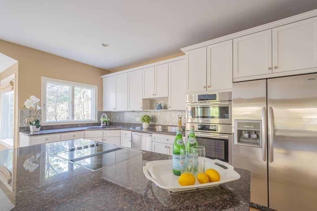 6 Johnson Farm Road Lexington, MA 02420 - Photo 15 of 42 a kitchen with stainless steel appliances granite countertop a refrigerator a stove a sink a dining table and chairs with wooden floor