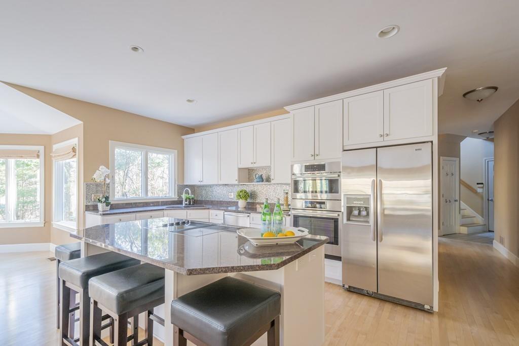6 Johnson Farm Road Lexington, MA 02420 - Photo 10 of 42 a kitchen with stainless steel appliances granite countertop a refrigerator a sink a stove and white cabinets with wooden floor