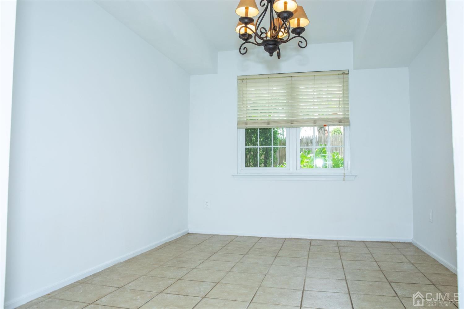 111 Keystone Court, Unit A Woodbridge, NJ 07095 - Photo 11 of 33 an empty room with windows and chandelier