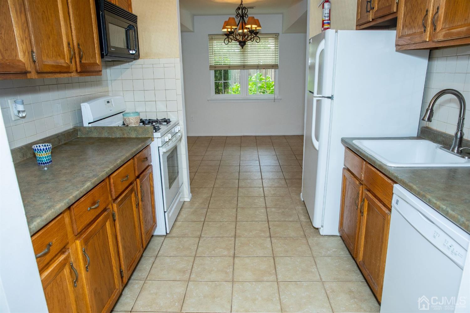 111 Keystone Court, Unit A Woodbridge, NJ 07095 - Photo 14 of 33 a kitchen with stainless steel appliances granite countertop a sink stove and cabinets