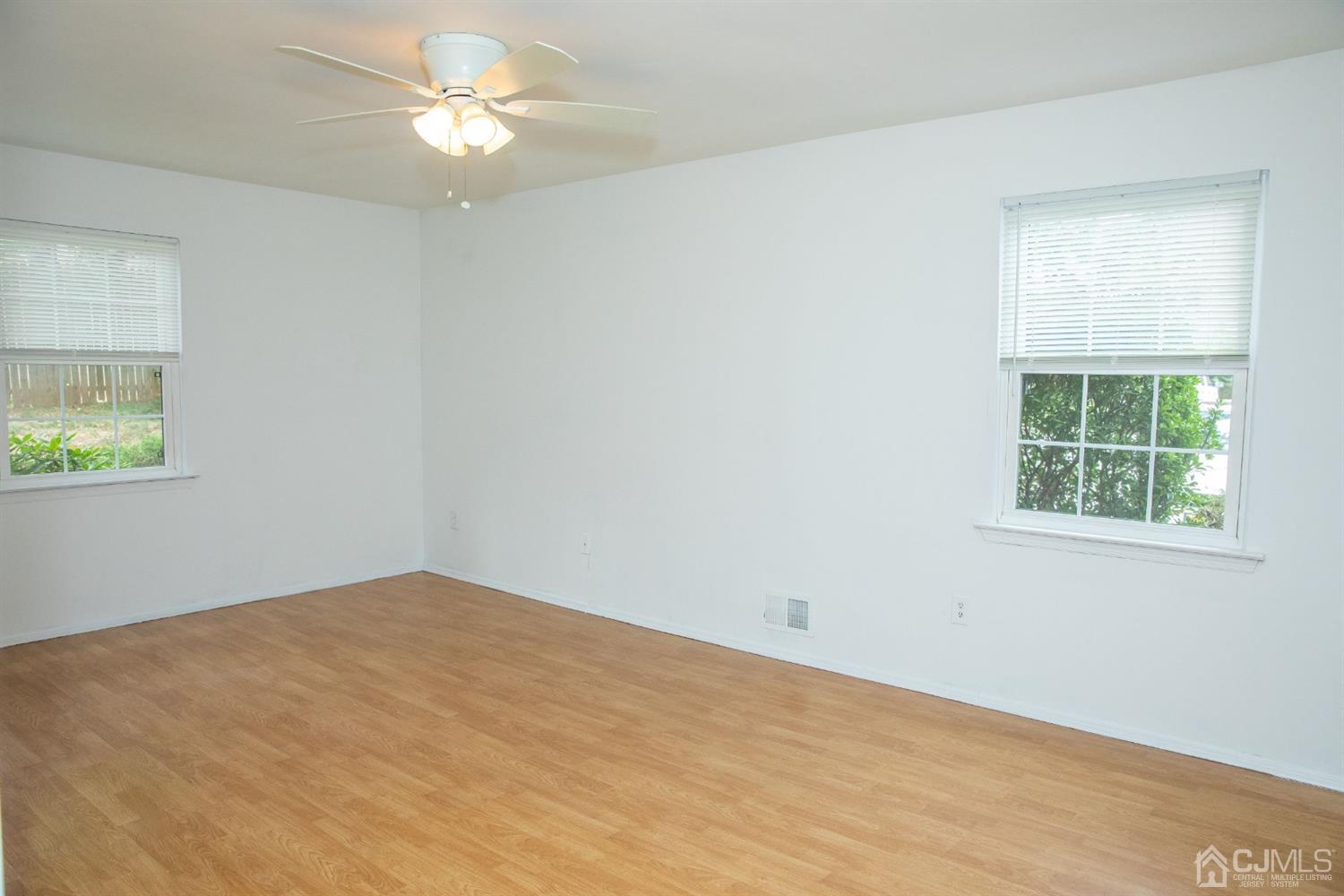 111 Keystone Court, Unit A Woodbridge, NJ 07095 - Photo 19 of 33 an empty room with a window and ceiling fan