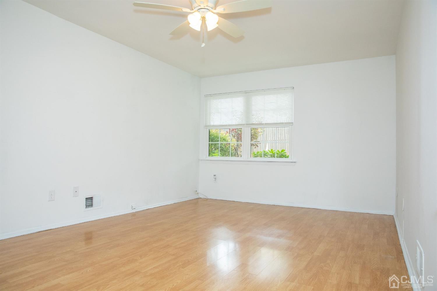 111 Keystone Court, Unit A Woodbridge, NJ 07095 - Photo 20 of 33 an empty room with a window and ceiling fan