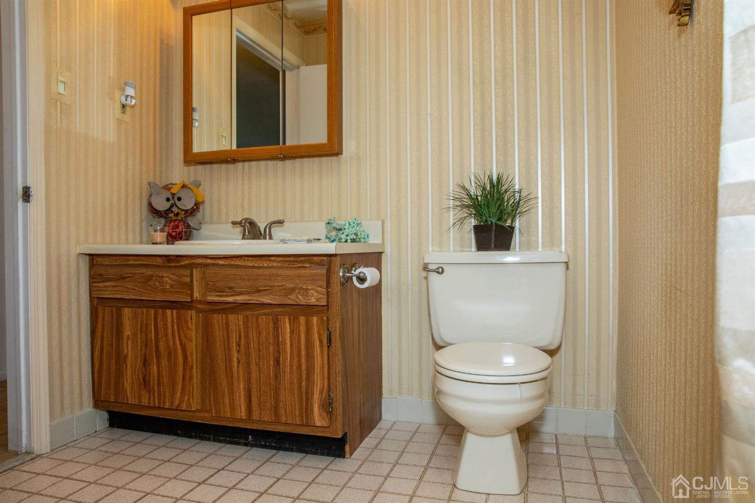 111 Keystone Court, Unit A Woodbridge, NJ 07095 - Photo 28 of 33 a bathroom with a toilet a sink and a mirror