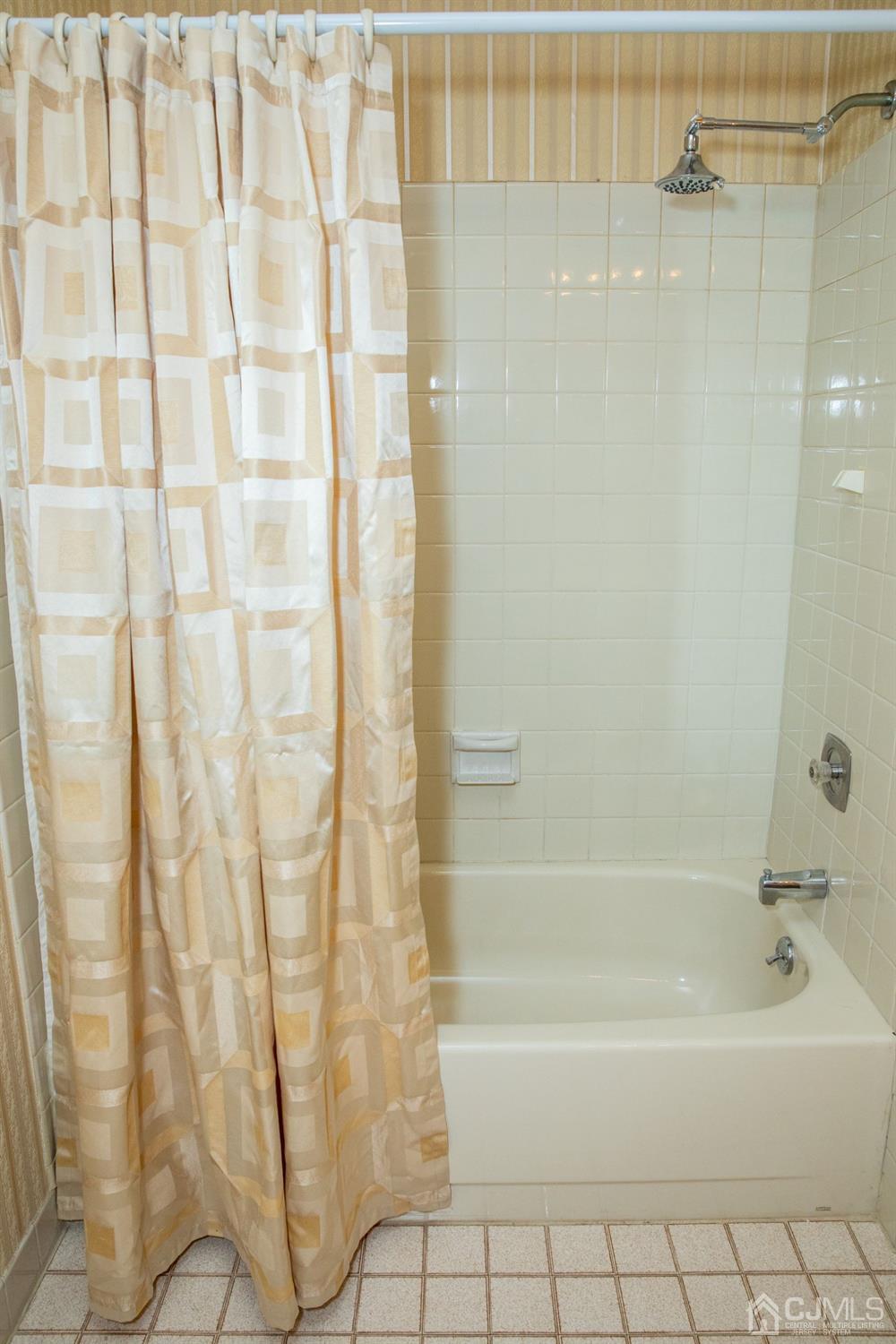 111 Keystone Court, Unit A Woodbridge, NJ 07095 - Photo 30 of 33 a bathroom with a shower curtain and a bathtub