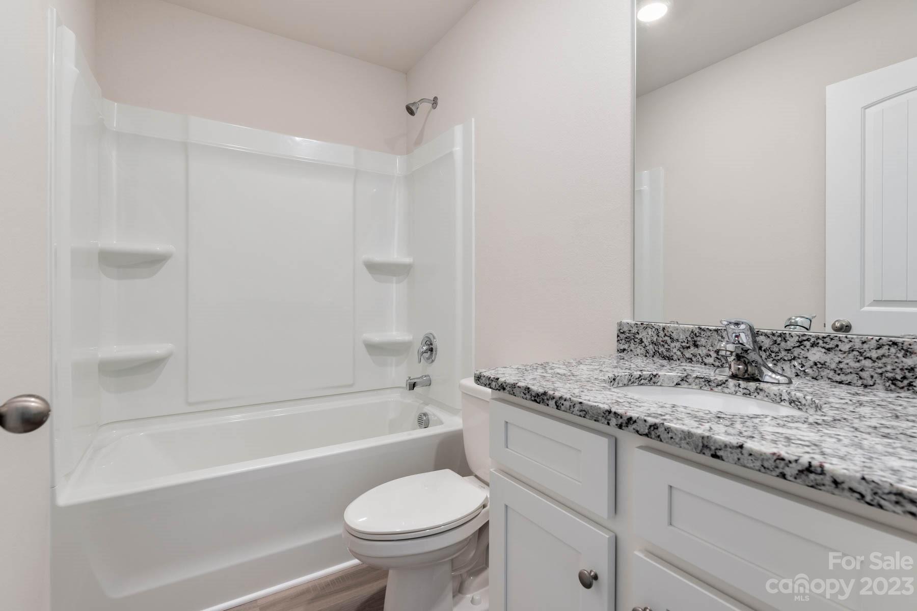 1612 Nia Road Charlotte, NC 28215 - Photo 15 of 15 a bathroom with a granite countertop sink toilet and bathtub