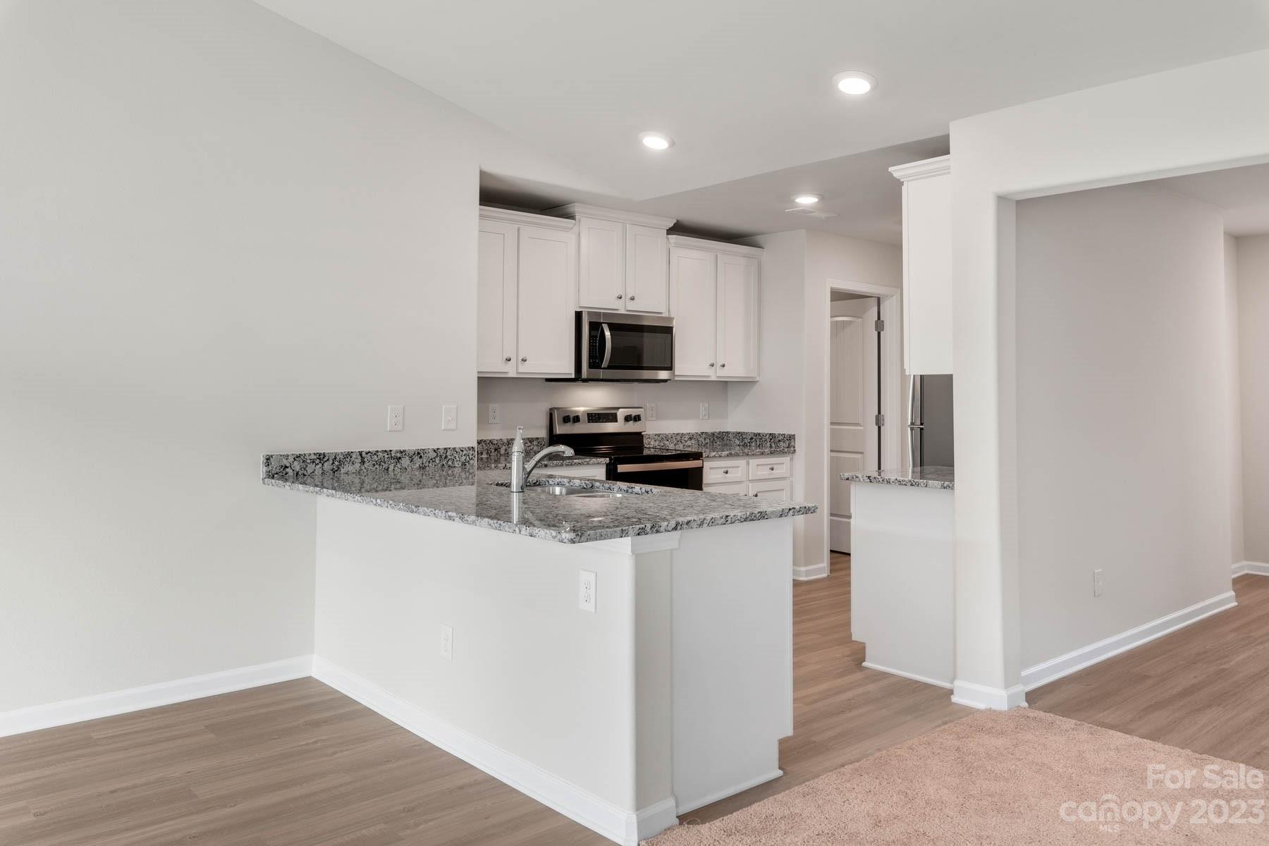1612 Nia Road Charlotte, NC 28215 - Photo 5 of 15 a kitchen with granite countertop a refrigerator and a stove top oven