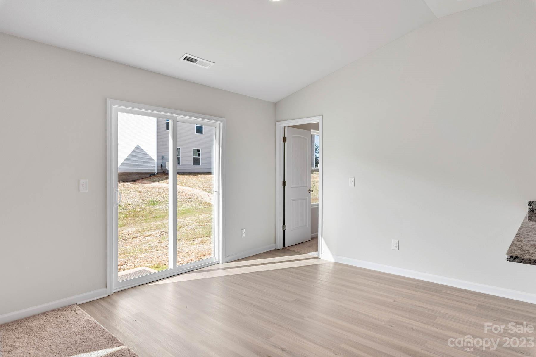 1612 Nia Road Charlotte, NC 28215 - Photo 6 of 15 a view of an empty room with wooden floor and a window