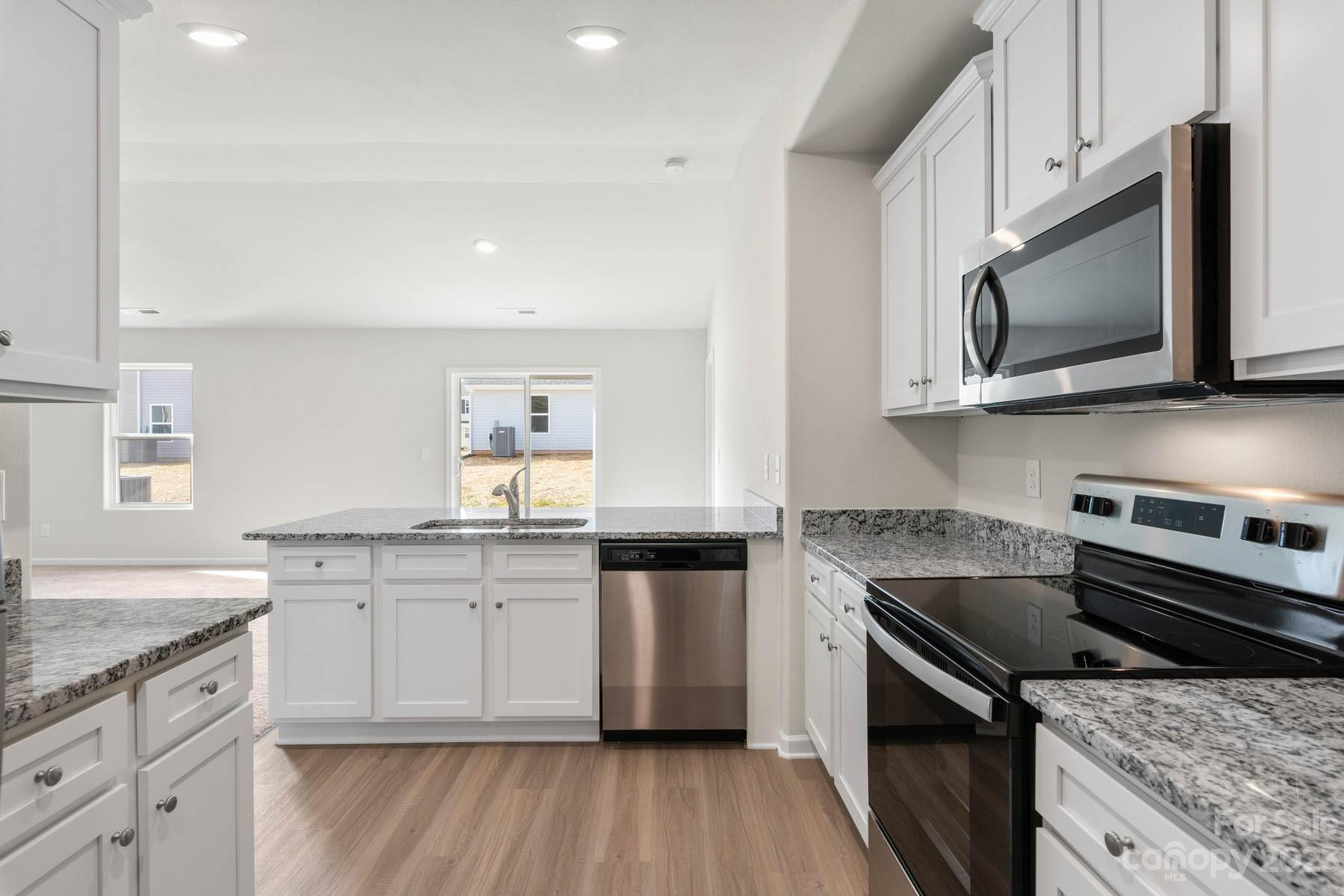 1612 Nia Road Charlotte, NC 28215 - Photo 10 of 15 a kitchen with stainless steel appliances granite countertop a stove top oven microwave and cabinets