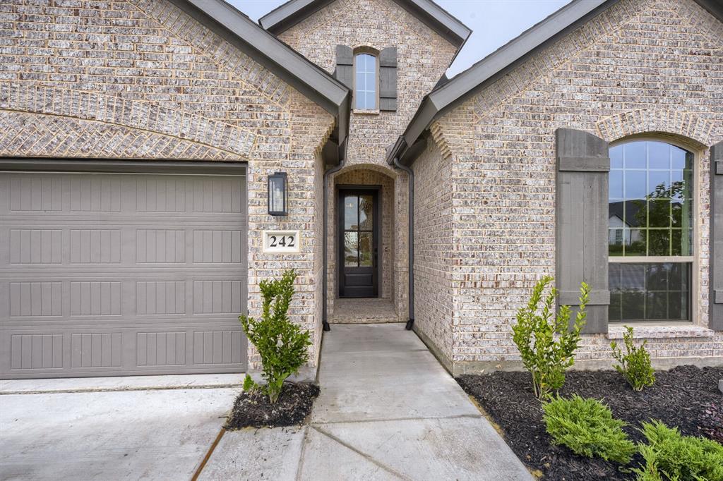 242 Buffalo Boulevard Rhome, TX 76078 - Photo 2 of 28 a front view of a house with a garden