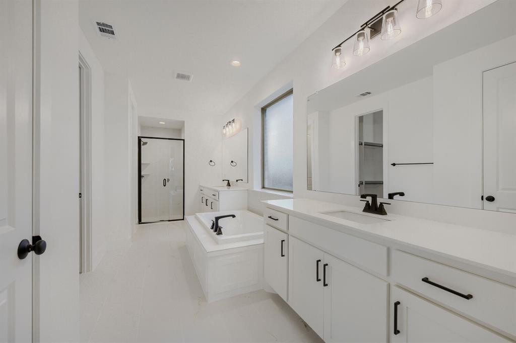 242 Buffalo Boulevard Rhome, TX 76078 - Photo 23 of 28 a spacious bathroom with a double vanity sink a mirror and a bathtub