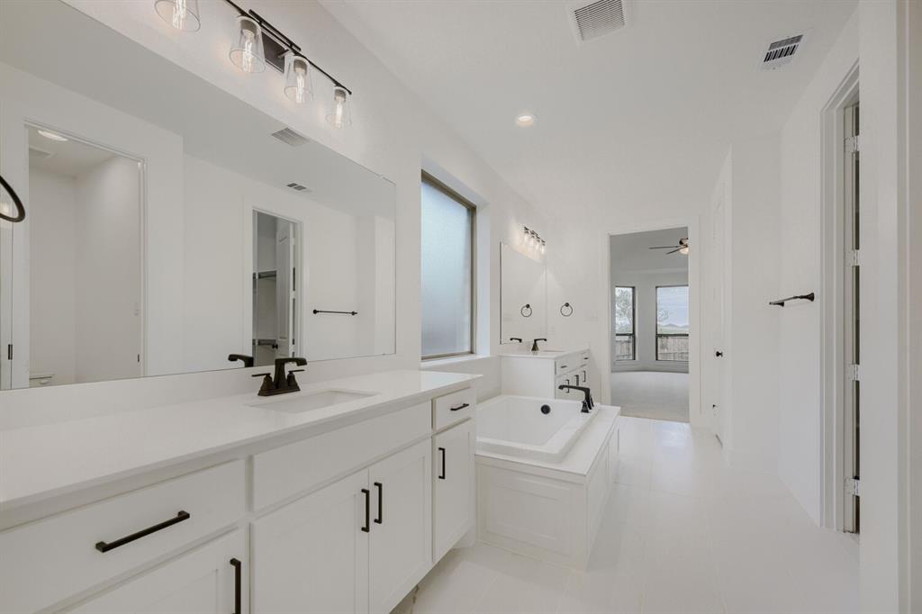242 Buffalo Boulevard Rhome, TX 76078 - Photo 24 of 28 a spacious bathroom with a tub sink and mirror