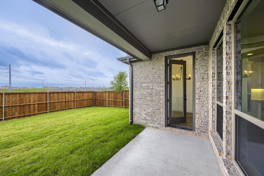 242 Buffalo Boulevard Rhome, TX 76078 - Photo 27 of 28 a view of a backyard with brick wall and a small cabin