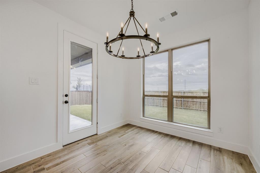 242 Buffalo Boulevard Rhome, TX 76078 - Photo 4 of 28 an empty room with wooden floor and windows