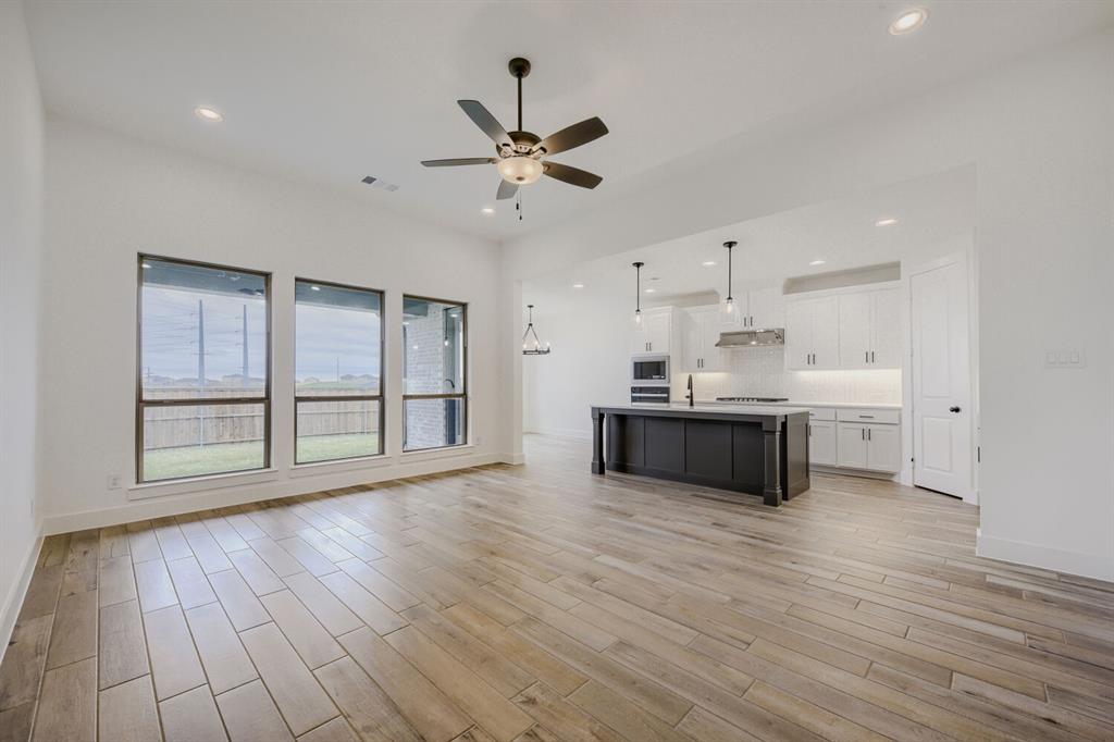 242 Buffalo Boulevard Rhome, TX 76078 - Photo 5 of 28 a large kitchen with stainless steel appliances a large counter top a wooden floors and a large window