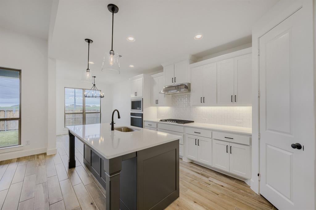 242 Buffalo Boulevard Rhome, TX 76078 - Photo 7 of 28 a kitchen with stainless steel appliances granite countertop a sink stove and wooden floor