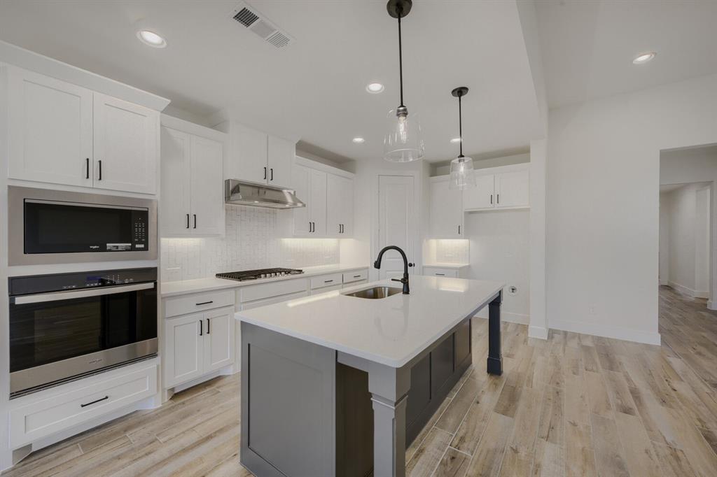 242 Buffalo Boulevard Rhome, TX 76078 - Photo 8 of 28 a kitchen with a sink a stove and a refrigerator