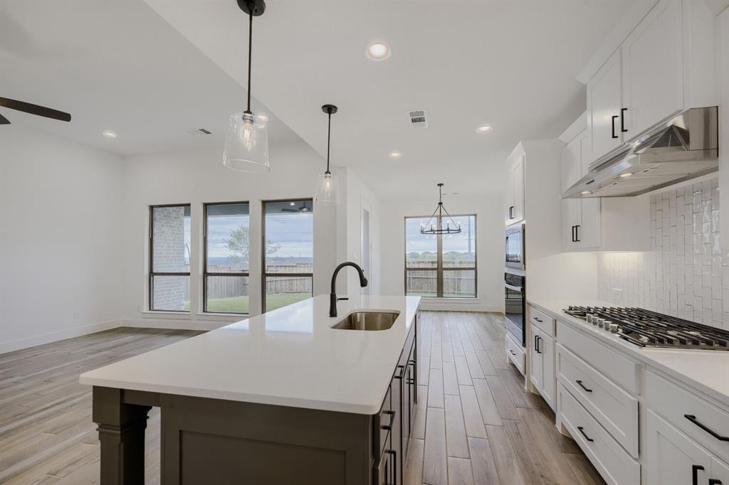 242 Buffalo Boulevard Rhome, TX 76078 - Photo 9 of 28 a kitchen with kitchen island a counter space a sink stainless steel appliances and cabinets