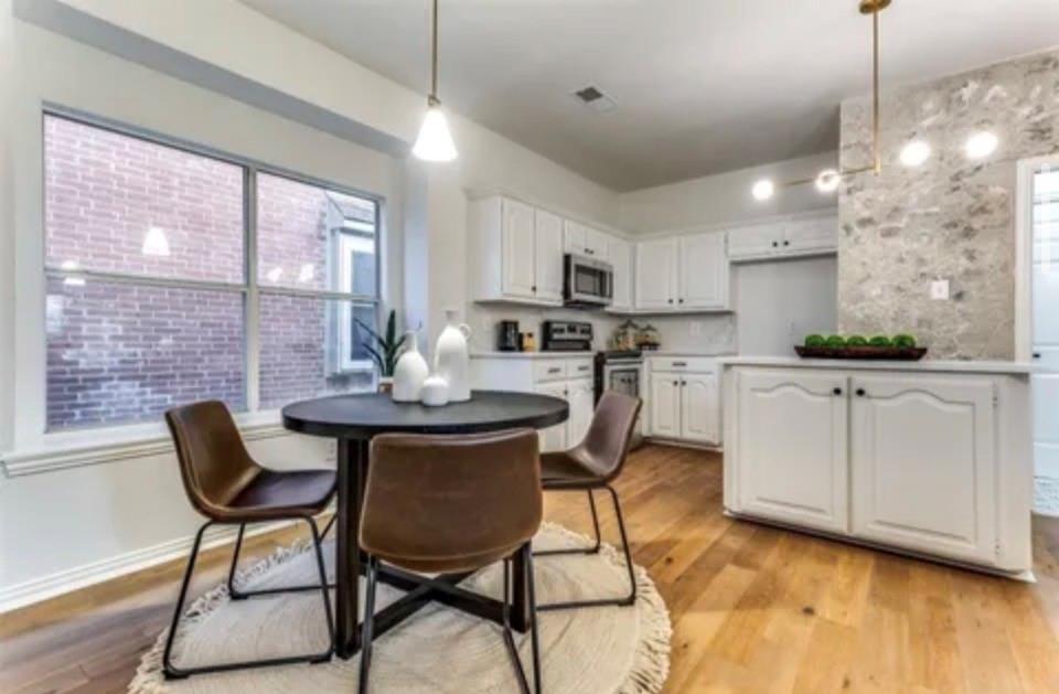 1377 Riley Drive Carrollton, TX 75007 - Photo 12 of 27 a kitchen with stainless steel appliances kitchen island granite countertop a dining table chairs and a refrigerator