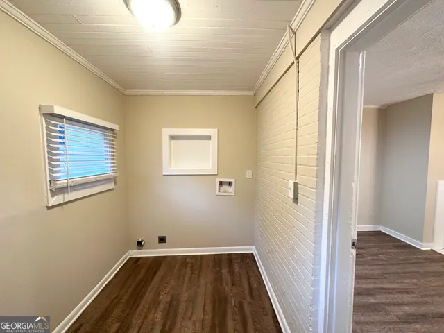 a view of a hallway with wooden floor and a bathroom