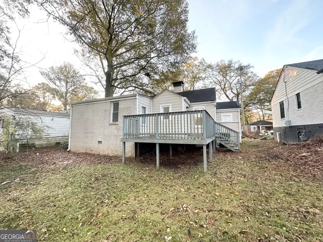 a view of a wooden house with a yard and deck