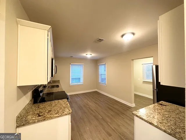a kitchen with granite countertop sink and refrigerator